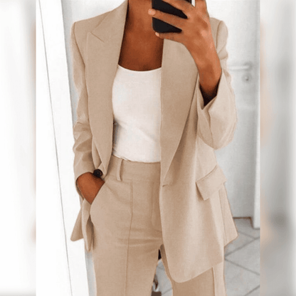 Beige Damenanzug mit Blazer und Hose, kombiniert mit weißem Top. Elegante Businessmode für Frauen, ideal für Büro und formelle Anlässe.