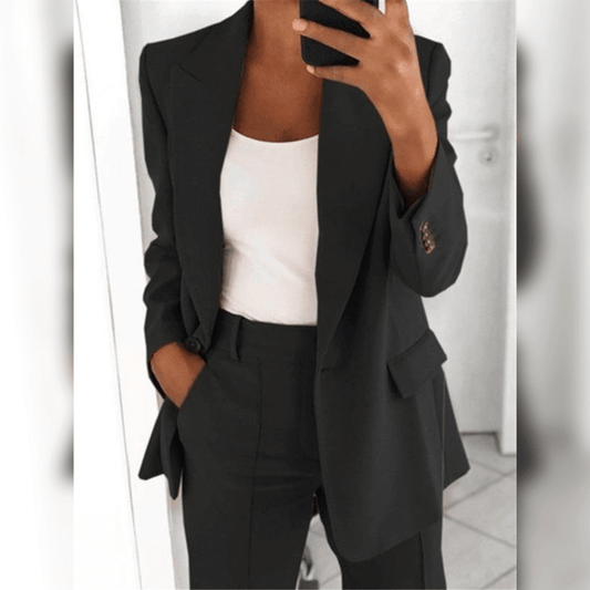 Schwarzer Damenanzug mit weißem Top, modisch und elegant, Business-Look, Frau im Spiegel, moderne Büro-Outfit-Inspiration.
