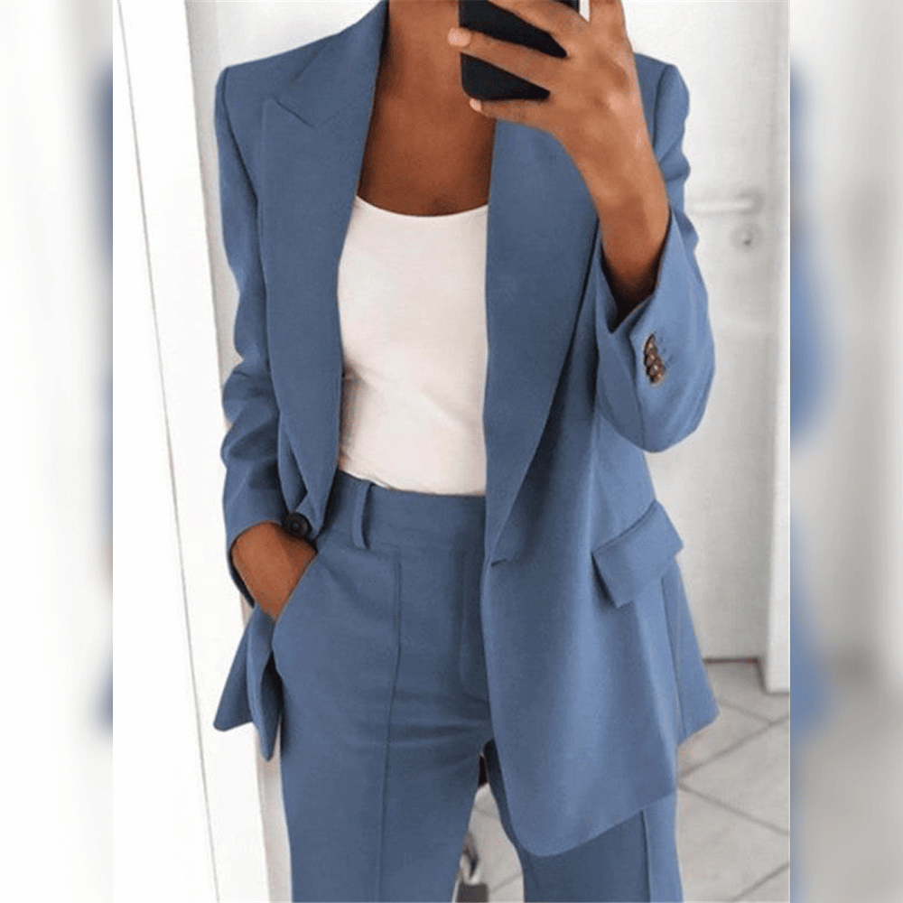 Blauer Damenanzug mit weißem Top, modisches Business-Outfit, Frau im Spiegel, eleganter Blazer und Hose, stilvolle Bürobekleidung.