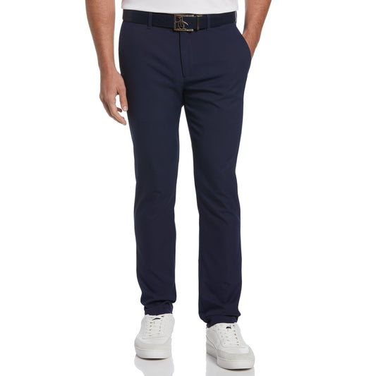 Dunkelblaue Herren-Chinohose, getragen mit weißem Polohemd und weißen Sneakers. Elegante Freizeitmode, ideal für stilvolle Anlässe.