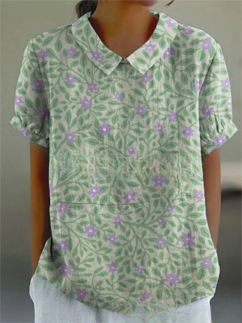 Damenbluse mit grünem Blatt- und lila Blumenmuster, kurzärmelig, klassischer Kragen, lässiger Stil, ideal für Sommermode.