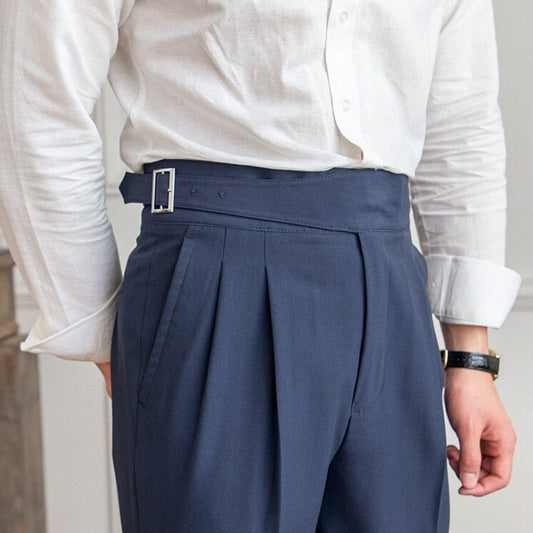 Eleganter Mann in weißem Hemd und blauer Anzughose mit hoher Taille und Gürtelschnalle, modisches Herrenoutfit, Business-Look.