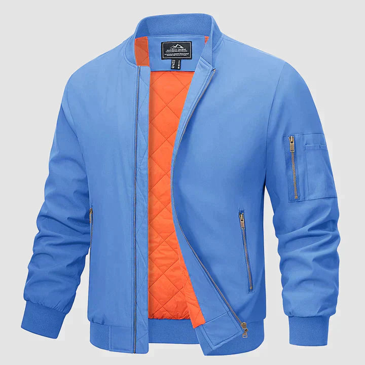 Blaue Bomberjacke mit orangefarbenem Innenfutter, Reißverschlusstaschen und gerippten Bündchen. Modische Herrenjacke, ideal für Herbst und Frühling.