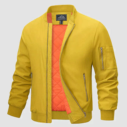 Gelbe Bomberjacke mit orangefarbenem Innenfutter, Reißverschlusstaschen und Ärmeltasche. Modische Herrenjacke, ideal für Herbst und Frühling.