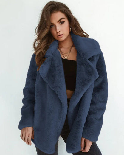 Frau in dunkelblauer Kunstpelzjacke, schwarzem Top und Jeans. Modetrend, Wintermode, stilvolle Damenbekleidung, eleganter Look.