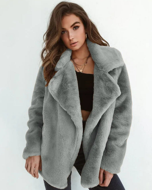 Frau in grauem Kunstpelzmantel, modisch, elegant, Wintermode, Damenbekleidung, trendiger Look, stilvolle Jacke, lässiger Chic.