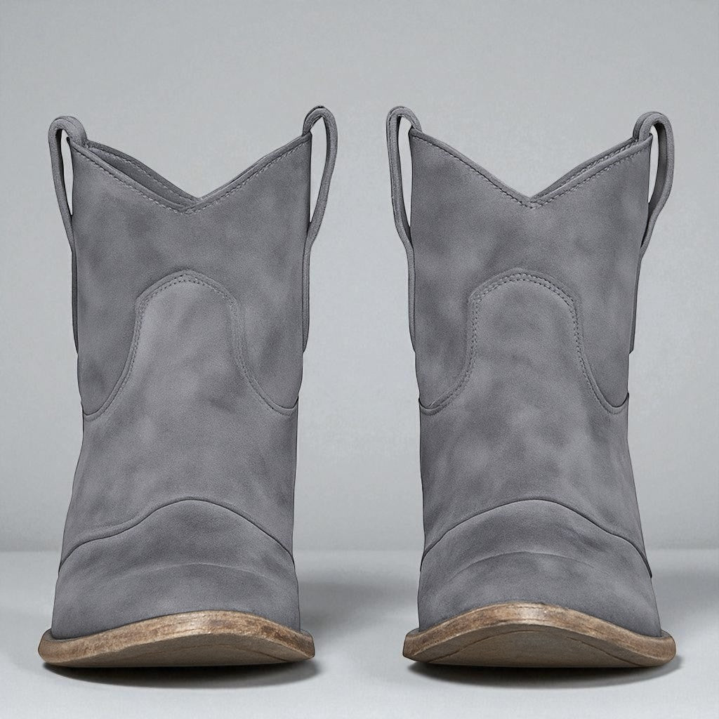 Graue Cowboystiefel aus Wildleder mit Holzsohle, Vorderansicht. Modische Westernstiefel für Damen, ideal für Herbst- und Winteroutfits.
