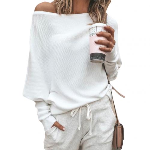 Frau in weißem Pullover und grauer Jogginghose hält Kaffeebecher. Lässige Mode, gemütlicher Look, Freizeitkleidung, Streetstyle.