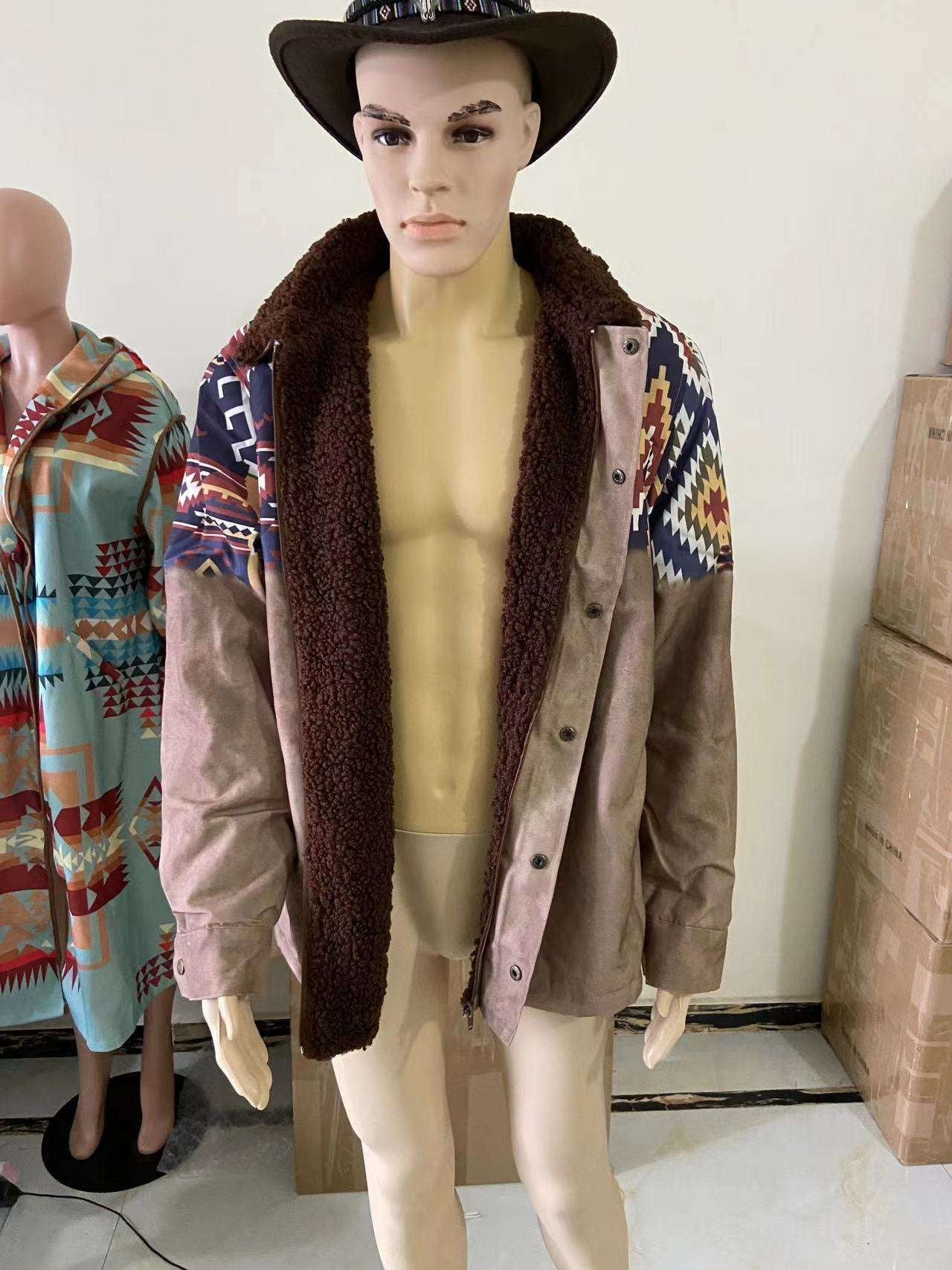 Ein Schaufensterpuppe trägt eine braune Wildlederjacke mit buntem Aztekenmuster und Fellkragen, daneben ein weiterer Mantel mit ähnlichem Design.