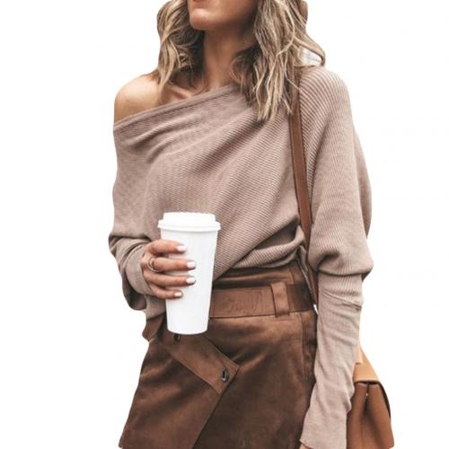 Frau in beigem Off-Shoulder-Pullover und braunem Rock hält Kaffeebecher. Modetrend, Herbstoutfit, Streetstyle, Damenmode.