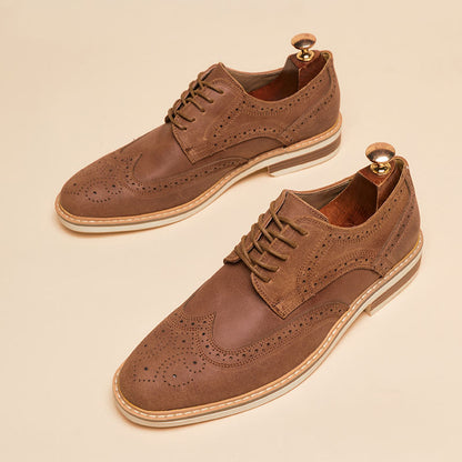 Braune Herren-Brogues aus Leder mit Lochmuster und Holz-Schuhspanner auf beigem Hintergrund. Elegante Herrenschuhe, klassisches Design.