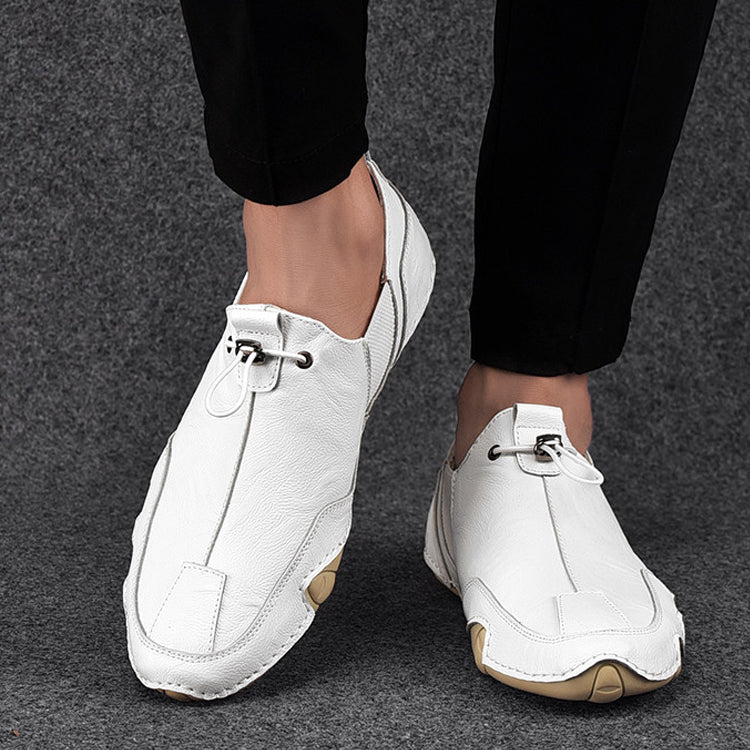 Weiße Herrenschuhe aus Leder, modern und elegant, auf grauem Teppich. Perfekt für formelle Anlässe oder stilvolle Freizeitkleidung.
