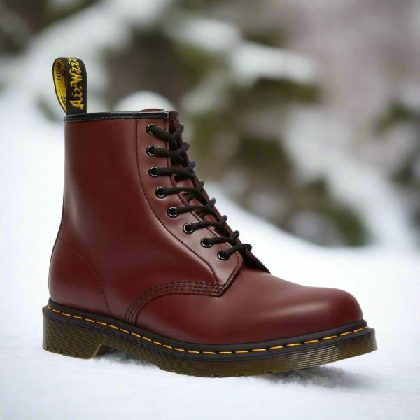 Klassischer brauner Lederstiefel im Schnee, robustes Design, gelbe Naht, ideal für Wintermode und Outdoor-Aktivitäten.