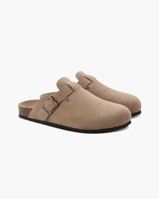 Beige Wildleder-Clogs mit Schnalle, Birkenstock-Stil, seitliche Ansicht. Komfortable, modische Schuhe für Damen und Herren. Ideal für Freizeit und Alltag.