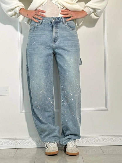 Damen-Jeans mit Glitzer-Details, lässiger Schnitt, kombiniert mit weißen Sneakers. Modetrend 2023, bequeme Freizeitkleidung.