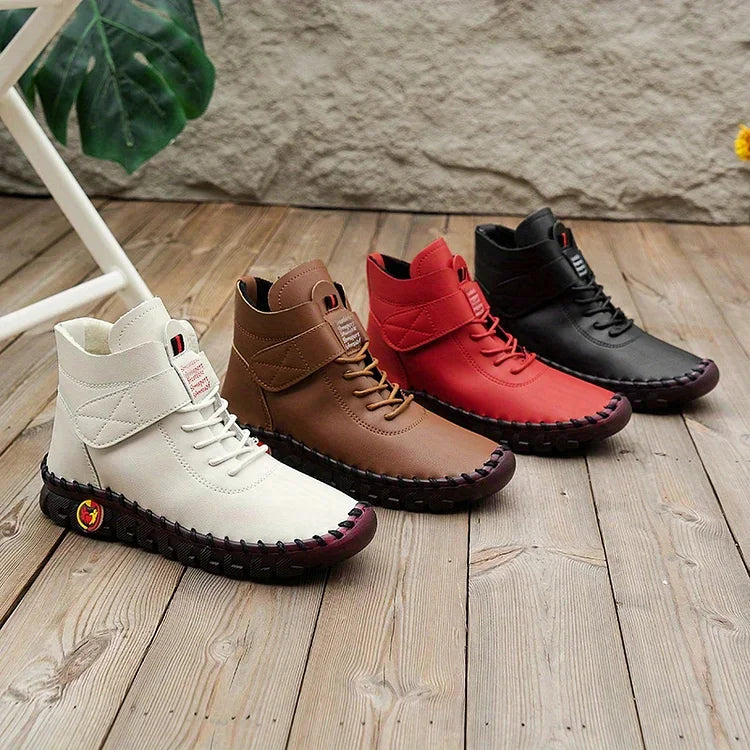 Vier Paar modische Herrenstiefel in Weiß, Braun, Rot und Schwarz auf Holzboden. Bequeme, stilvolle Schuhe für Herbst und Winter.
