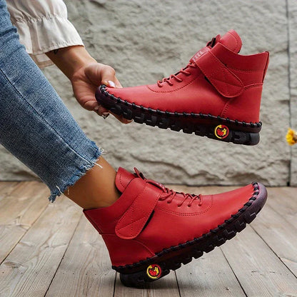 Rote Damenstiefel mit Klettverschluss, lässig und modisch, auf Holzfußboden. Perfekt für Herbstmode und bequemen Alltagsstil.