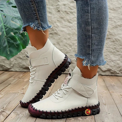 Damenstiefel in Weiß mit Klettverschluss, robustem Profil und modischen Jeans. Outdoor-Schuhe, ideal für Herbstmode und Freizeitaktivitäten.