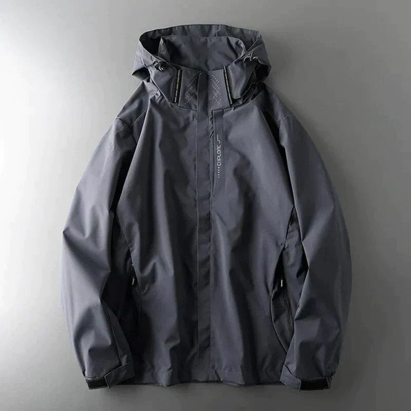Dunkelgraue wasserdichte Herrenjacke mit Kapuze, Reißverschluss und Taschen, ideal für Outdoor-Aktivitäten und Regenwetter.