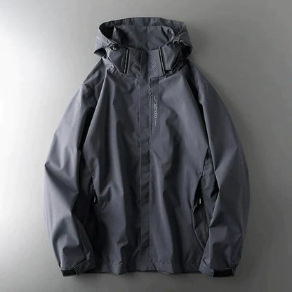 Dunkelgraue wasserdichte Herrenjacke mit Kapuze, Reißverschluss und Taschen, ideal für Outdoor-Aktivitäten und Regenwetter.