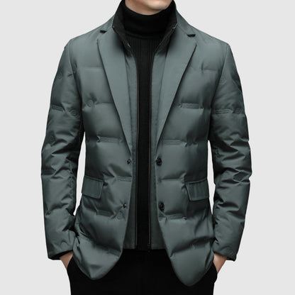 Mann in grauem, gestepptem Blazer mit schwarzem Rollkragenpullover. Elegante Wintermode, stilvoller Herrenmantel, moderne Herrenbekleidung.