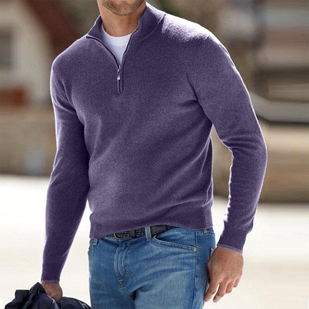 Mann in lila Pullover mit Reißverschluss und blauer Jeans, hält Jacke. Mode für Herren, Freizeitkleidung, stilvoller Look.