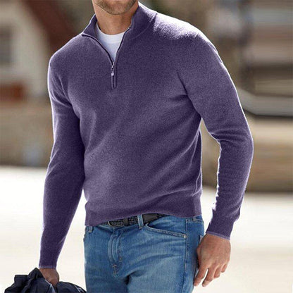 Mann in lila Pullover mit Reißverschluss und blauer Jeans, hält Jacke. Mode für Herren, Freizeitkleidung, stilvoller Look.
