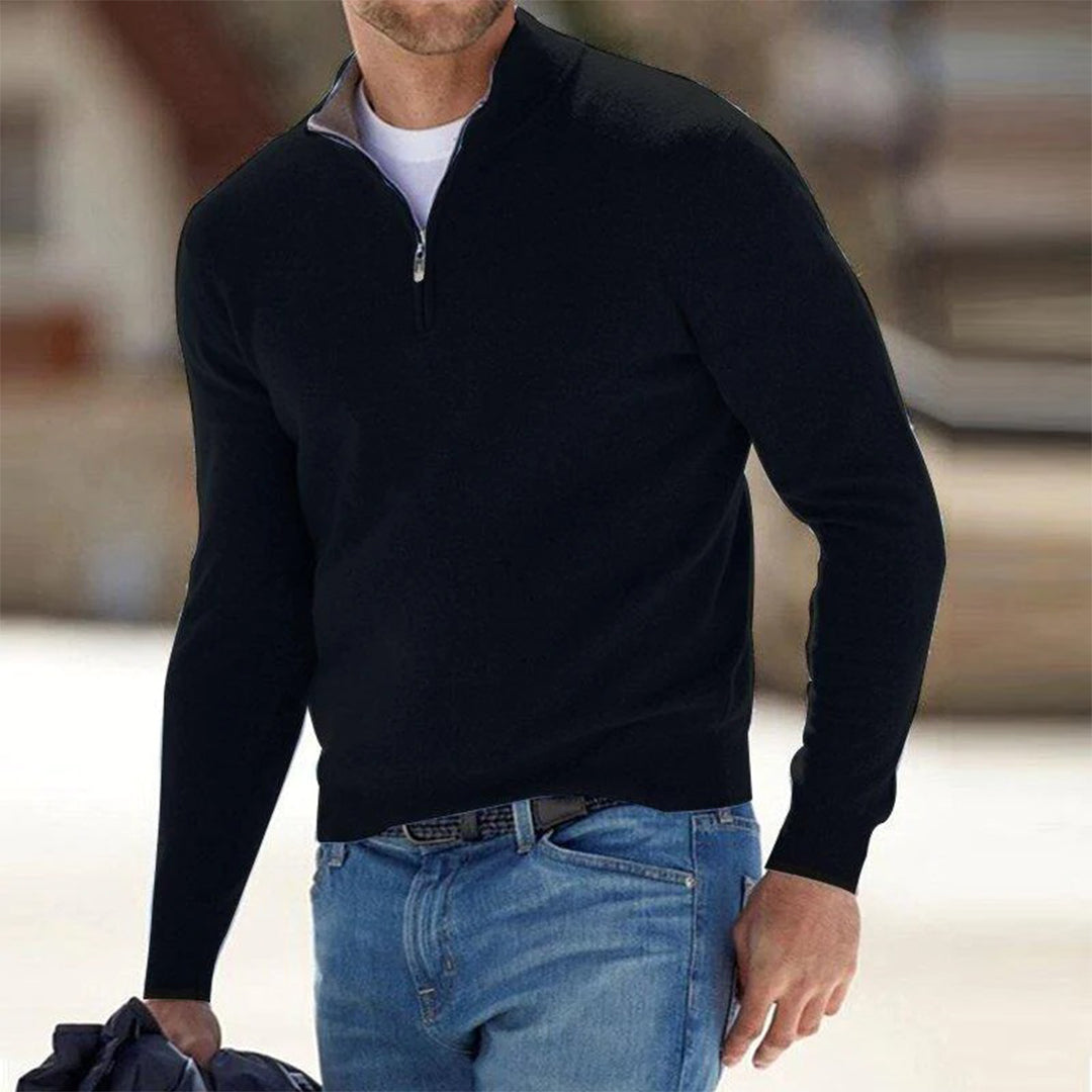 Mann in schwarzem Pullover mit Reißverschluss und blauer Jeans im Freien. Wintermode, Herrenbekleidung, stilvoller Freizeitlook.