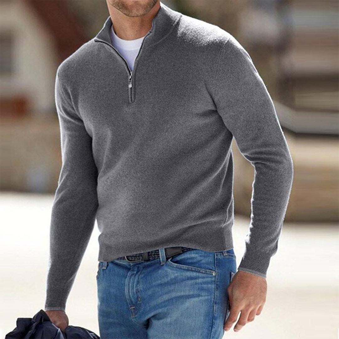 Grauer Herrenpullover mit Reißverschluss, kombiniert mit blauer Jeans. Modischer Freizeitlook für Männer, ideal für kühle Tage.