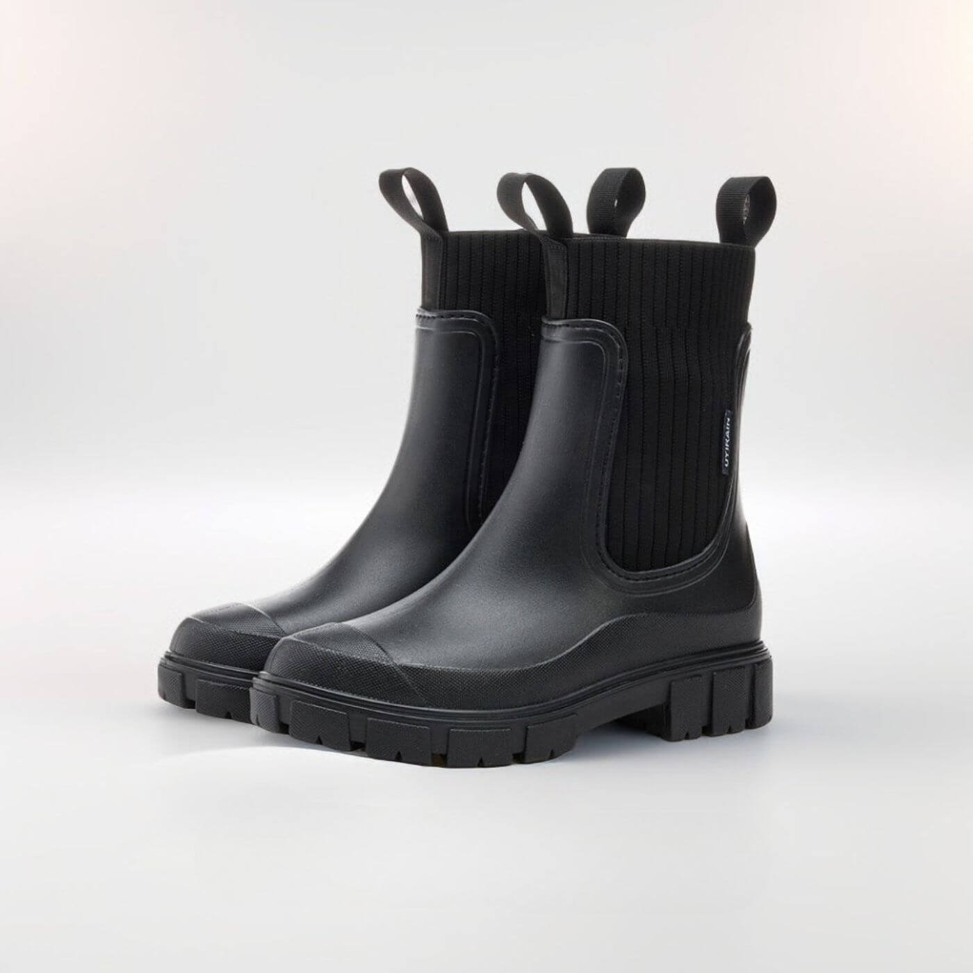 Schwarze Gummistiefel mit dicker Sohle und seitlichen Zuglaschen, modernes Design, ideal für Regenwetter und Outdoor-Aktivitäten.
