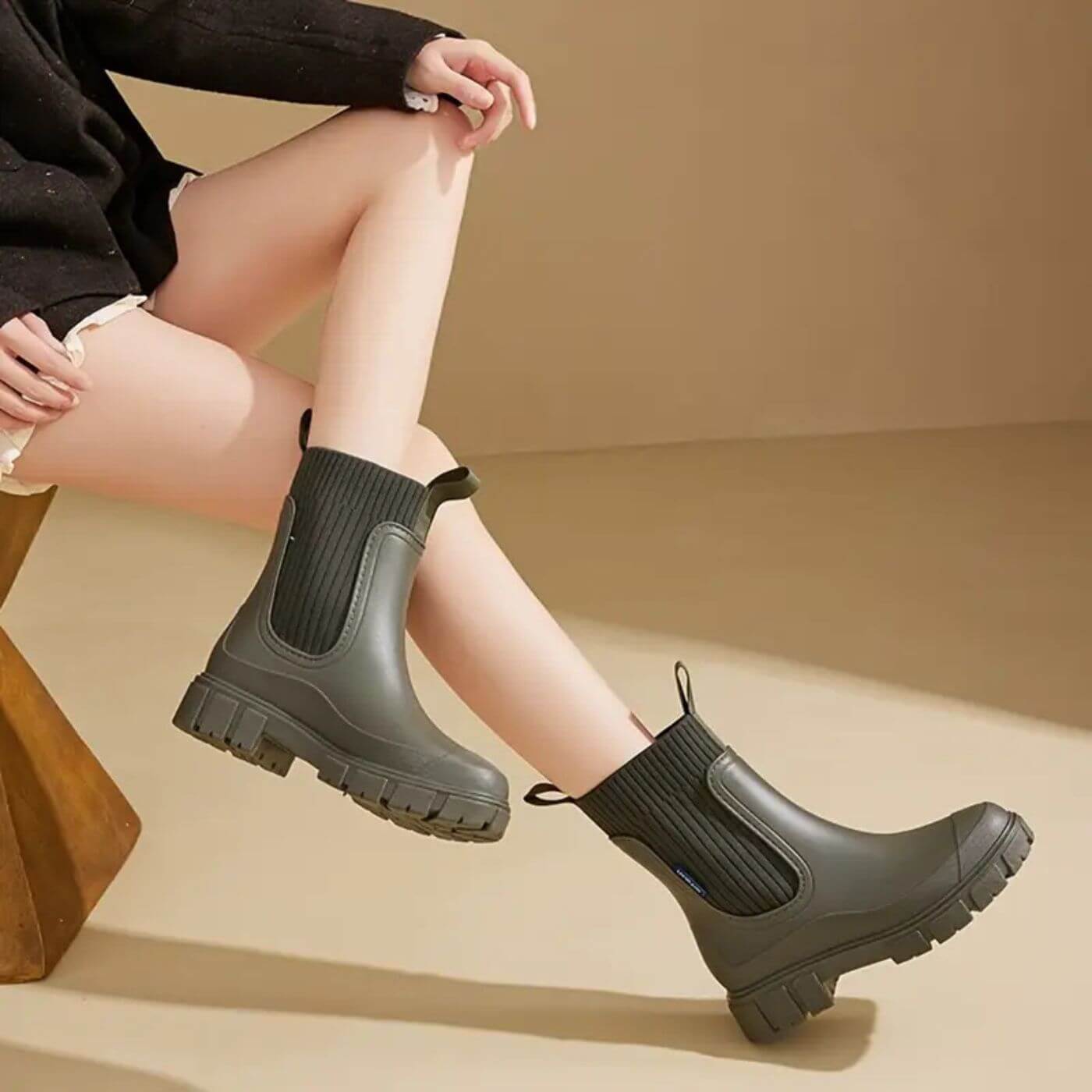 Damenbeine in olivgrünen Chelsea Boots mit dicker Sohle, modisch und robust, ideal für Herbstmode. Perfekt für stilvolle Outdoor-Aktivitäten.