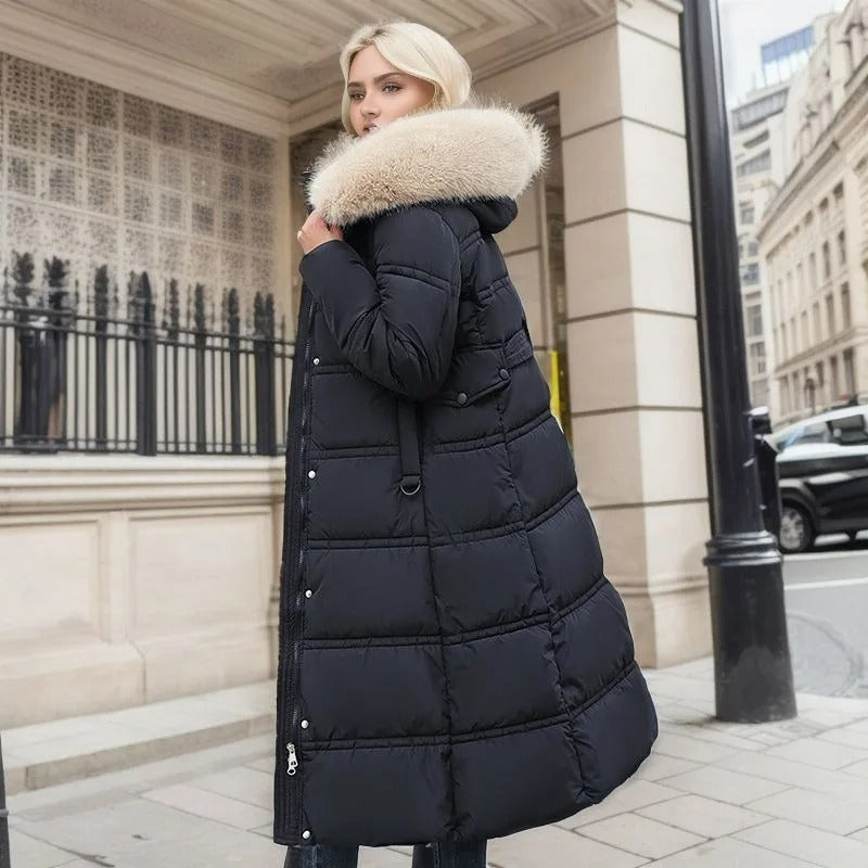 Blonde Frau in langem, schwarzem Daunenmantel mit Fellkapuze steht auf städtischer Straße. Wintermode, stilvoll, elegant, warm, Stadt.