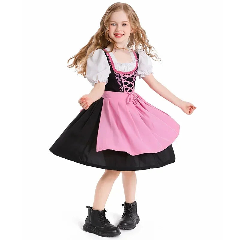 Mädchen im traditionellen Dirndl mit rosa Schürze und schwarzen Stiefeln, lächelnd und tanzend. Bayerische Tracht, Kinderkleidung, Oktoberfest.