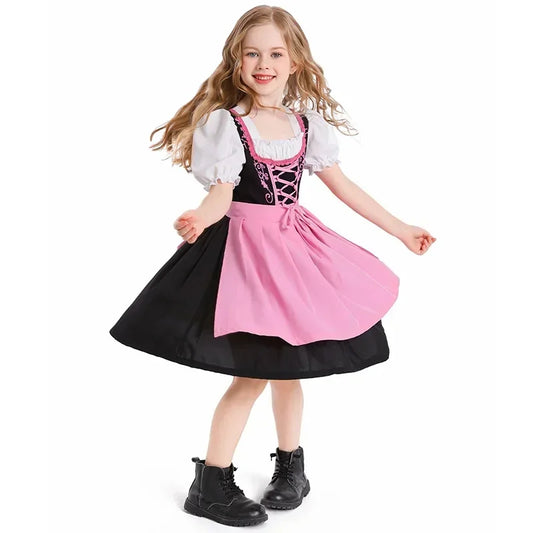 Mädchen im traditionellen Dirndl mit rosa Schürze und schwarzen Stiefeln, lächelnd und tanzend. Bayerische Tracht, Kinderkleidung, Oktoberfest.