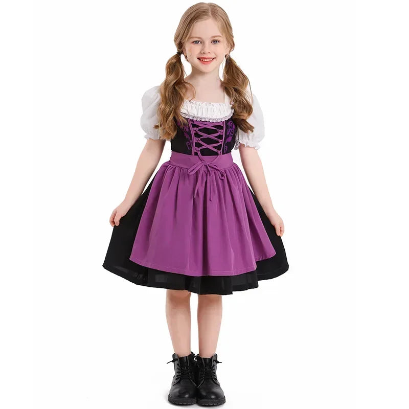 Mädchen im lila Dirndl mit weißer Bluse und schwarzen Stiefeln, traditionelles bayerisches Kleid, Oktoberfest, Trachtenmode, Kindertracht.