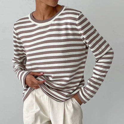 Person trägt gestreiftes Langarmshirt in Beige und Weiß, kombiniert mit beigen Hosen. Modischer Freizeitlook, ideal für Herbstmode.