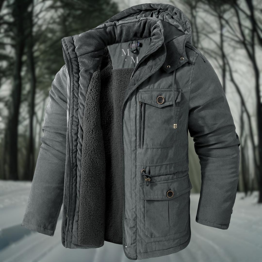 Graue Winterjacke mit Kapuze und Fleece-Innenfutter, ideal für kalte Temperaturen. Perfekt für Outdoor-Aktivitäten im Winterwald.