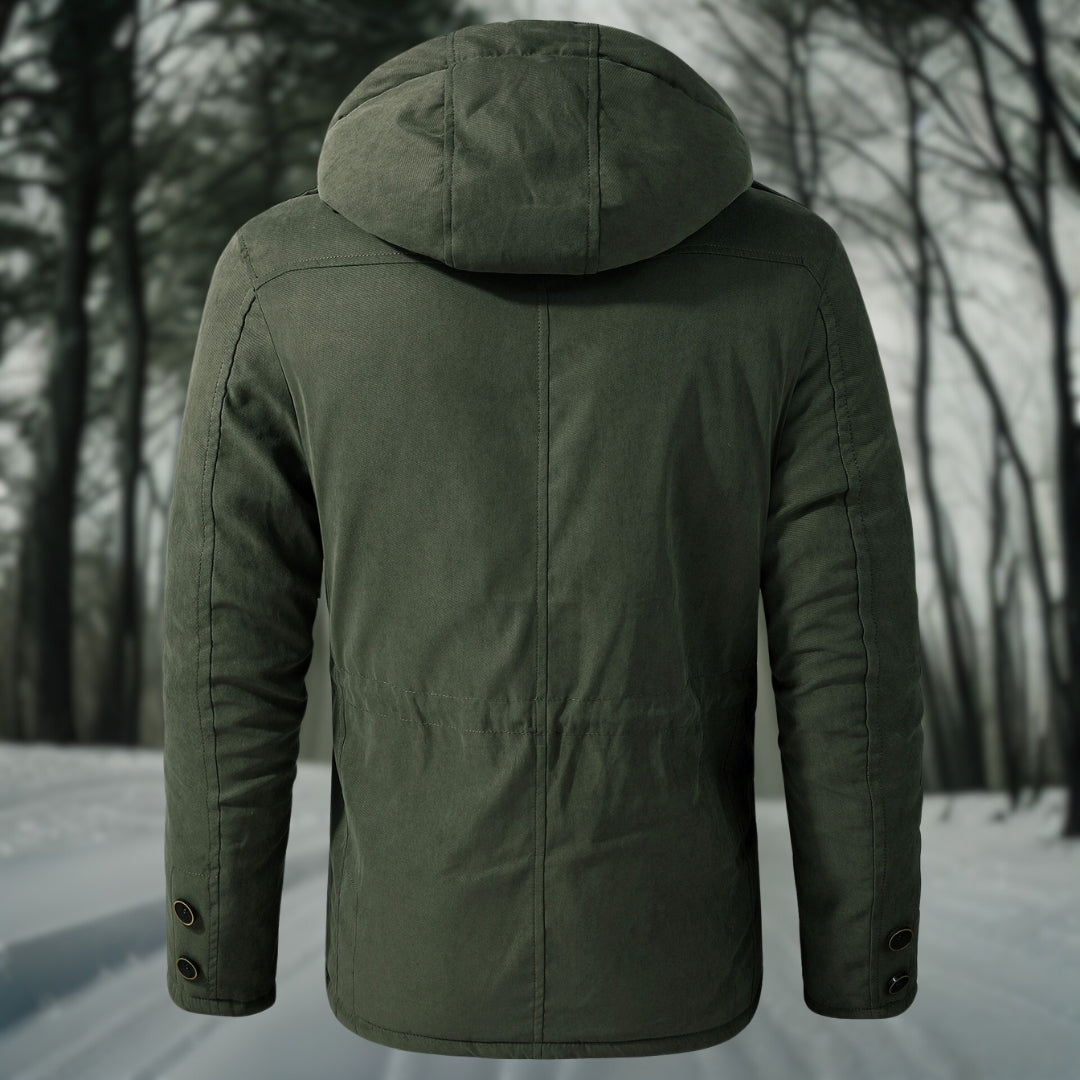 Grüne Winterjacke mit Kapuze, Rückansicht, im verschneiten Wald. Outdoor-Bekleidung, warm, stilvoll, ideal für kalte Wetterbedingungen.