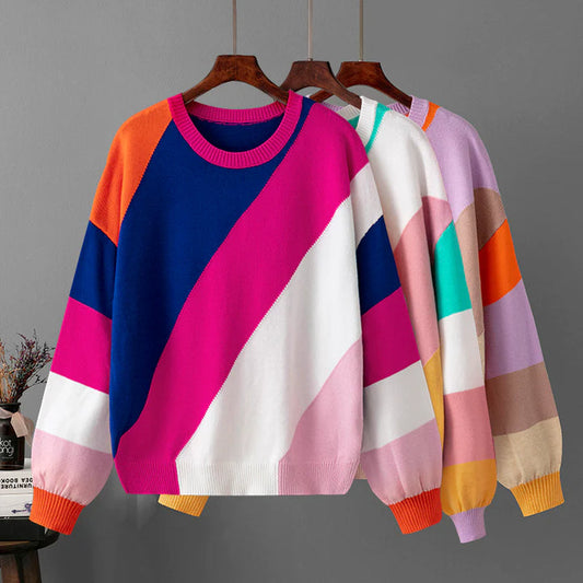 Bunte Strickpullover mit geometrischem Muster, hängend auf Holzkleiderbügeln. Modische Damenbekleidung, ideal für Herbst und Winter.