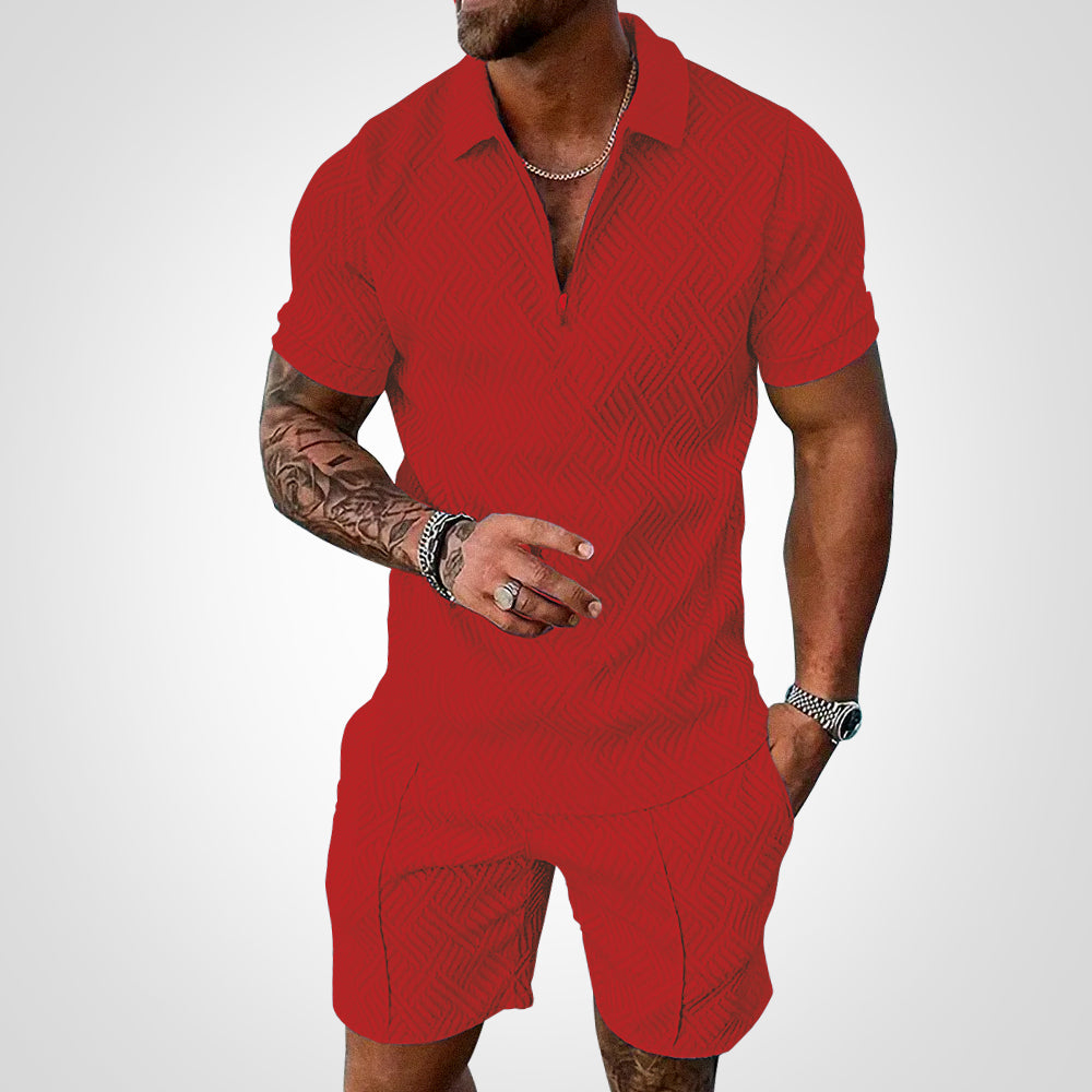 Mann in rotem, strukturiertem Poloshirt und Shorts, zeigt tätowierten Arm. Modischer Sommerlook, Herrenmode, Freizeitkleidung.