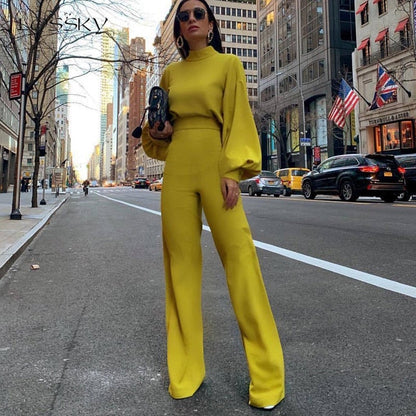 Frau in gelbem Outfit auf New Yorker Straße, hält schwarze Tasche, umgeben von Wolkenkratzern und gelben Taxis, Mode, Stadtleben, USA.