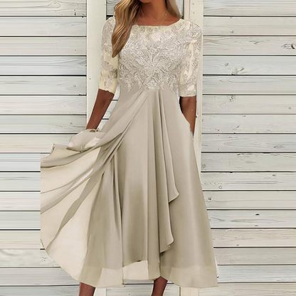 Elegantes cremefarbenes Kleid mit Spitzenoberteil und fließendem Rock, ideal für Hochzeiten oder festliche Anlässe. Damenmode, Abendkleid, elegant.