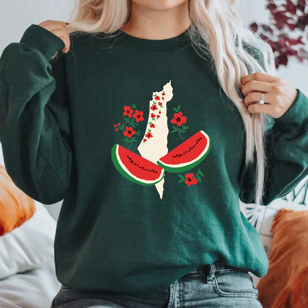 Frau trägt grünen Pullover mit Israel-Karte, verziert mit roten Blumen und Wassermelonen-Design. Modetrend, stilvolle Kleidung, Statement-Pullover.