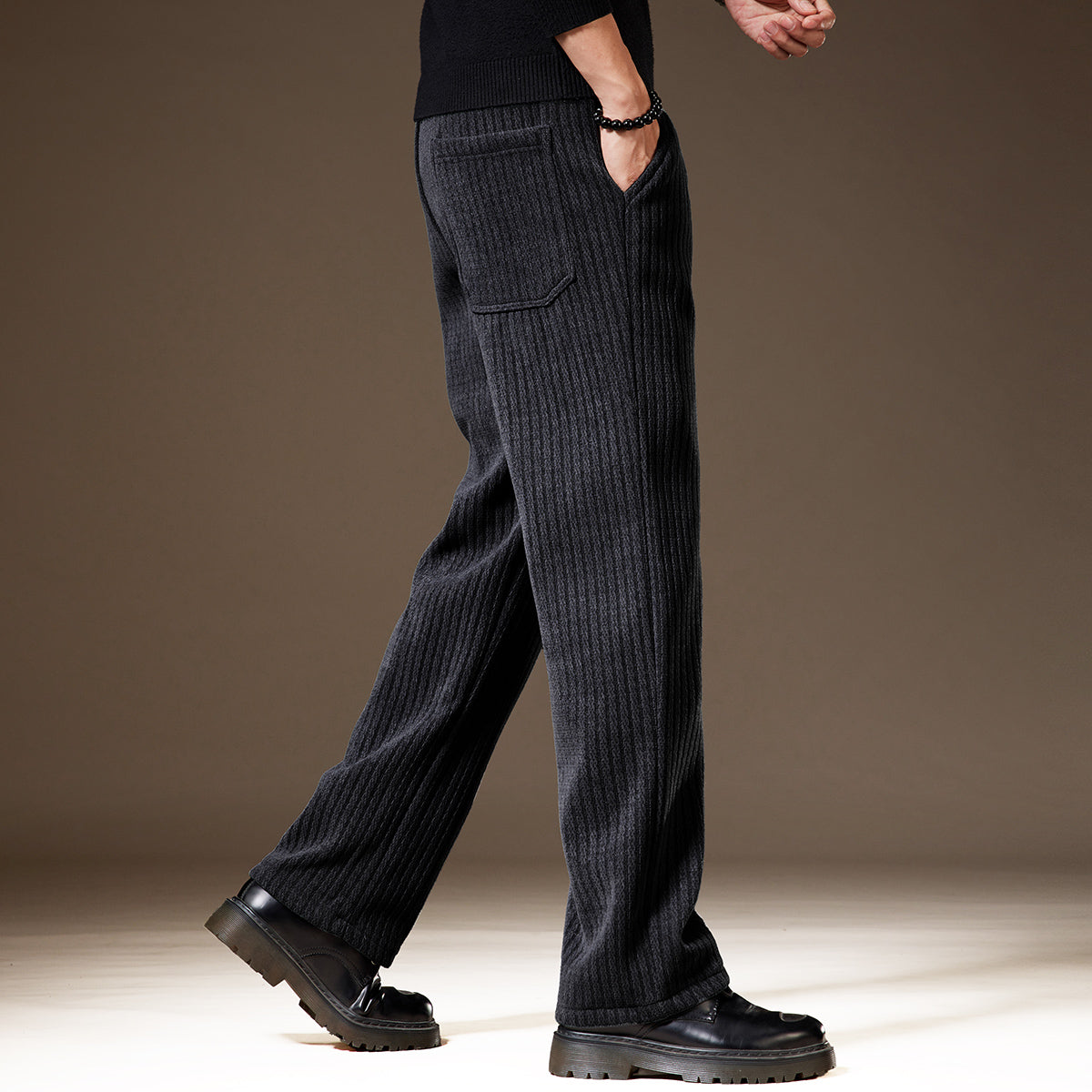 Schwarze, gerippte Herren-Hose aus Wolle, seitliche Taschen, getragen mit schwarzen Schuhen. Elegante, warme Wintermode für Herren.