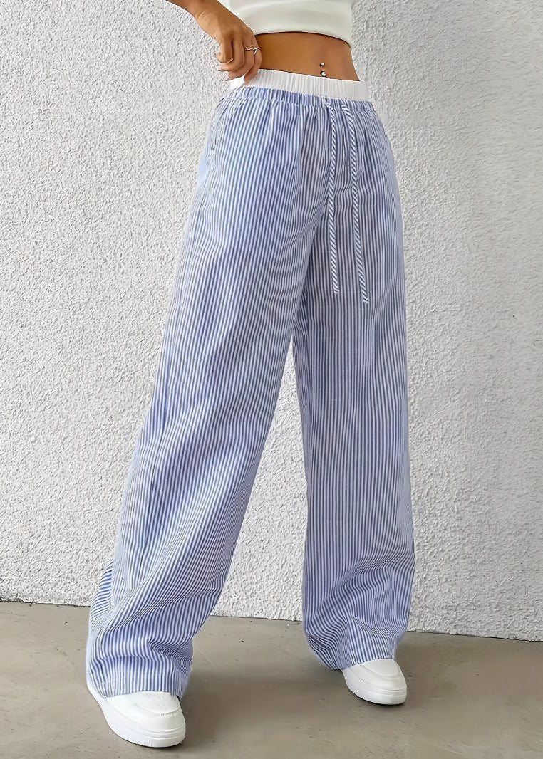 Damen gestreifte weite Hose, blau-weiß, mit Kordelzug, kombiniert mit weißem Top und Sneakers. Modetrend, lässiger Sommerlook.