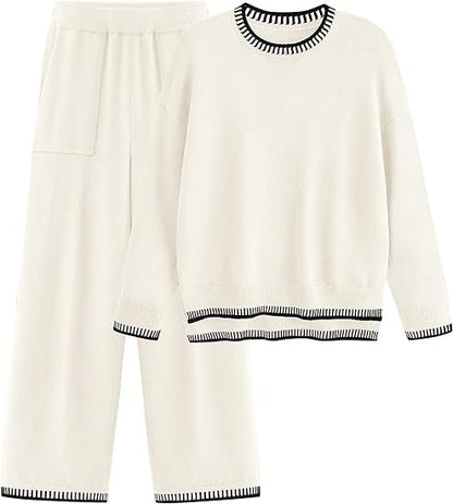Zweiteiliges Damen-Loungewear-Set in Weiß, bestehend aus Pullover und Hose mit schwarzen Streifen an Bündchen und Saum. Bequem und stilvoll.