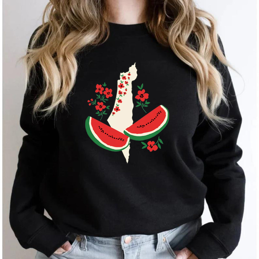 Frau trägt schwarzen Pullover mit Grafik von Wassermelonen und Blumen auf Landkarte. Modetrend, lässiger Stil, kreatives Design.