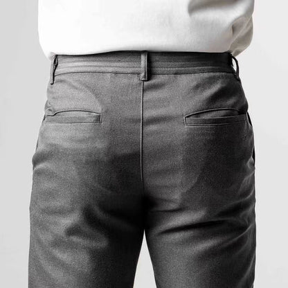 Rückansicht einer Person in grauer Anzughose und weißem Hemd. Businessmode, elegante Herrenbekleidung, formelle Kleidung.
