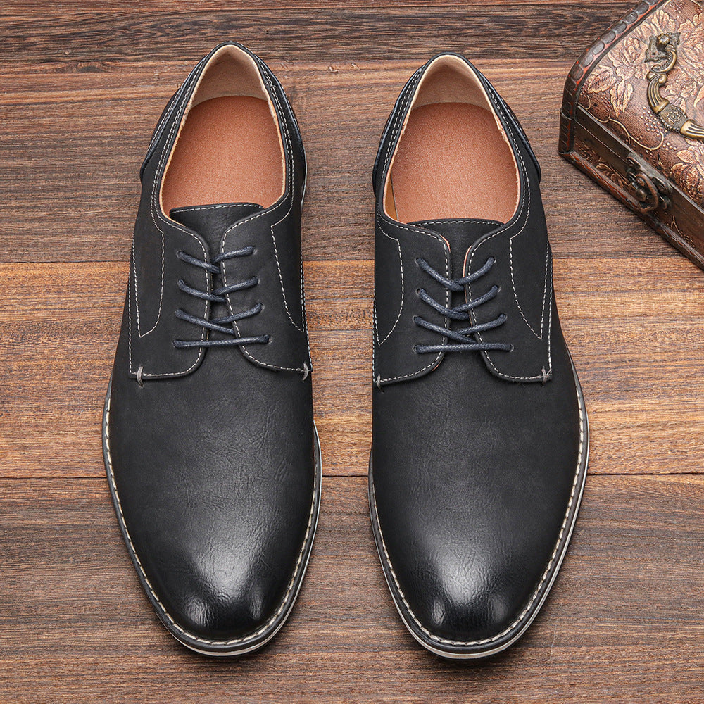 Schwarze Herren-Lederschnürschuhe auf Holzboden, elegante Business-Schuhe, klassische Mode, hochwertige Verarbeitung, stilvolle Herrenschuhe.