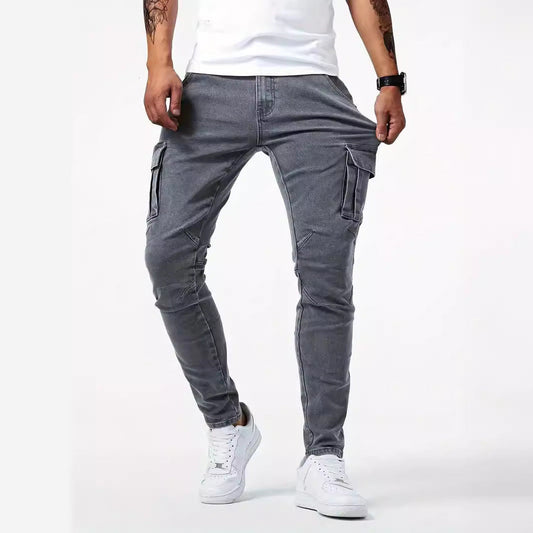 Graue Cargo-Jeans für Herren, schmal geschnitten, mit Seitentaschen, kombiniert mit weißen Sneakers und weißem T-Shirt. Ideal für lässige Outfits.